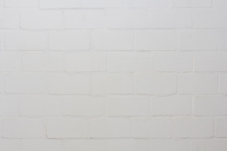 White painted wall with visible bricksの写真素材