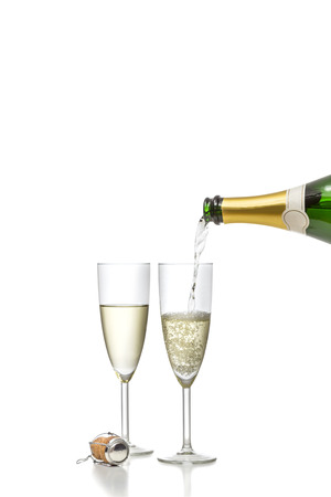 Champagne beeing filled into a glass with a second glass already beeing filled isolated on white backgroundの写真素材