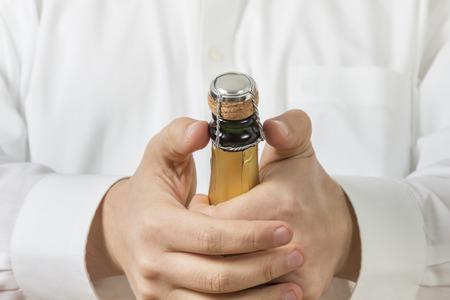 A Waiter in white shirt opens a Bottle of Champagneの写真素材