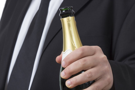 Man in a suit with a open bottle of Champagneの写真素材
