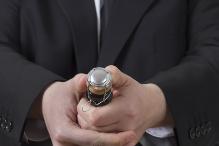 A man in a suit opening a bottle of Champagneの写真素材