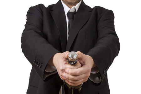 A man in a suit opening a bottle of Champagneの写真素材