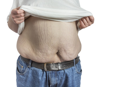 overweight Man in blue jeans lifting his white t-shirt isolated on white backgroundの写真素材