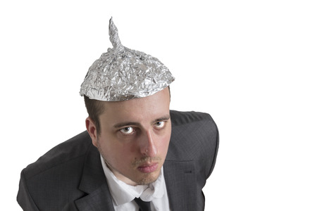 distraught looking conspiracy believer in suit with aluminum foil head isolated on white backgroundの写真素材
