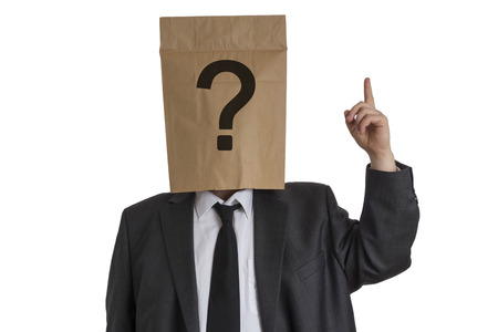 A Man in suit with a paper bag with a question mark on his head pointing upward isolated on white backgroundの写真素材