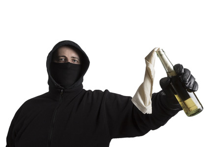 Hooded man in black dress holding a molotov cocktail isolated on white backgroundの写真素材