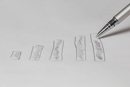 Silver pen drawing a diagram on a white sheet