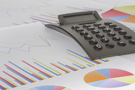 Calculator on a batch of colorful diagramsの写真素材
