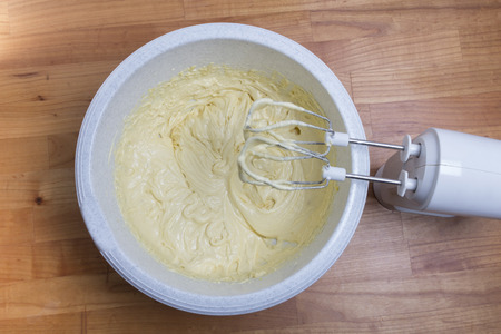 Raw dough in a white bowl on wooden tableの写真素材