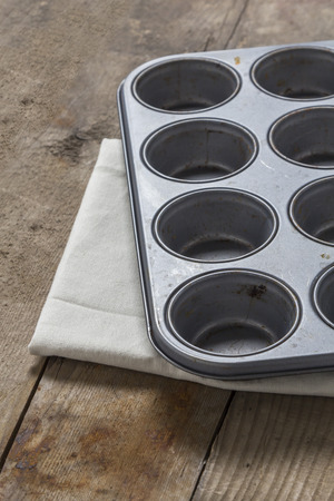 Muffin baking tray on a rustic wooden tableの写真素材
