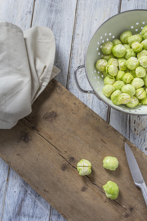 Brussels sprouts in a sieve on a wooden tableの写真素材