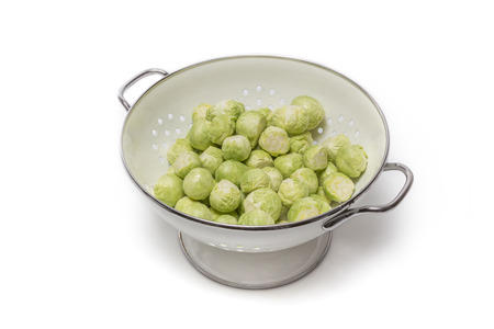 Brussels sprouts in a sieve isolated on white backgroundの写真素材