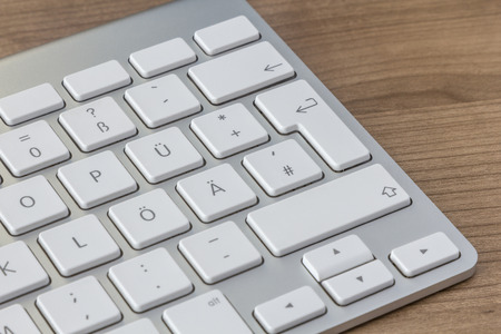 Detail view of modern keyboard on a wooden desktopの写真素材