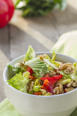 Green Salad with Red Pepper and walnuts in a bowlの写真素材