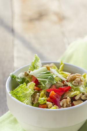 Green Salad with Red Pepper and walnuts in a bowlの写真素材