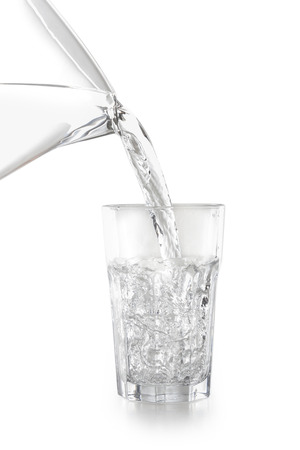 Water pouring into a glass isolated on white backgroundの写真素材