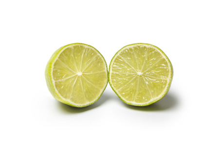 A Lime cut in two halfs isolated on white backgroundの写真素材