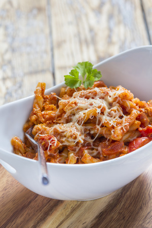 Pasta with bolognese and cheese in a modern white bowlの写真素材