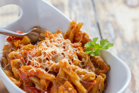 Pasta with bolognese and cheese in a modern white bowlの写真素材