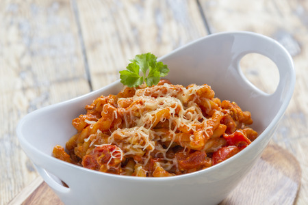 Pasta with bolognese and cheese in a modern white bowlの写真素材