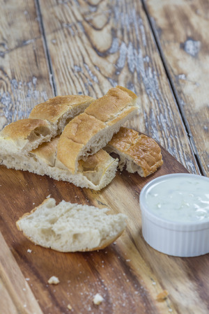 flat bread sticks with Tzatziki garlic dip on a rustic wooden tableの写真素材