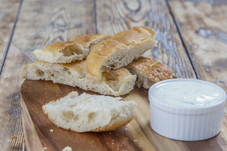 flat bread sticks with Tzatziki garlic dip on a rustic wooden tableの写真素材