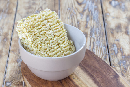 Block of Raw Asian Noodles in Bowl on a rustic wooden tableの写真素材