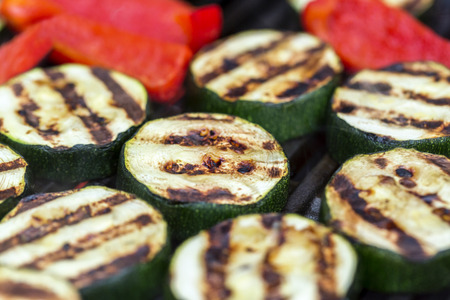 Zucchini and red pepper on a bbq grillの写真素材