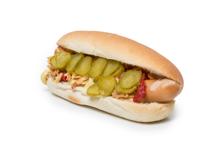 Hot Dog sausage in a bun with roasted onions, pickles, ketchup and mustard on white backgroundの写真素材