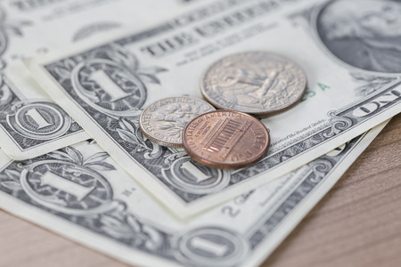 Closeup of Dollar Notes and Coins on a wooden tableの写真素材