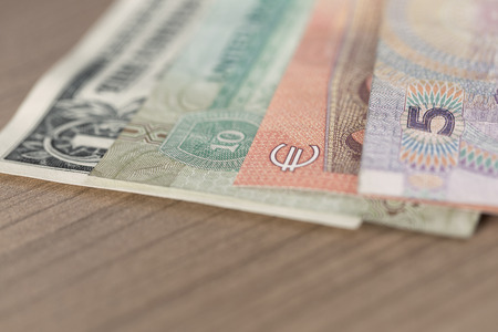 Chinese Renminbi Euro UAE Dirham and US dollar banknotes on wooden table
