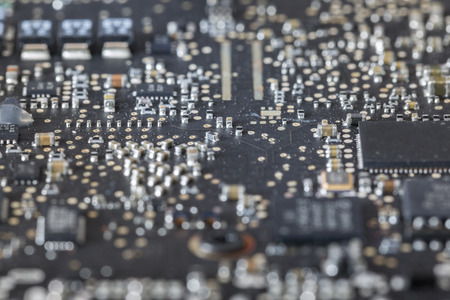 Detail view of condensers and microchips on a black mainboardの写真素材