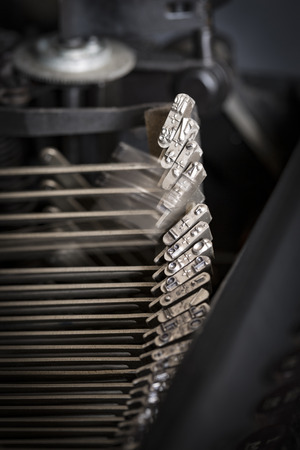 Detail view of typebars in a typewriter with one bar moving