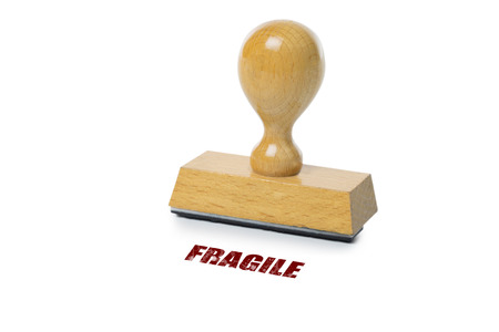Fragile printed in red ink with wooden Rubber stamp isolated on white backgroundの写真素材