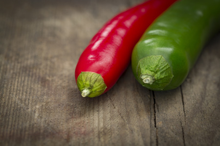 Closeup of a red and green Chilli on rustic wooden tableの写真素材