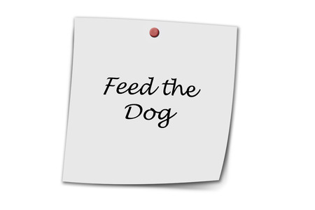 Feed the dog written on a memo pinned on a cork boardの写真素材