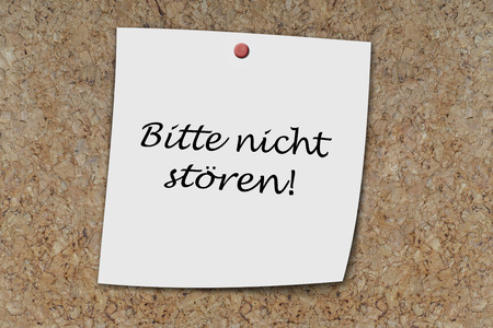 bitte nicht stören (german do not disturb) written on a memo pinned on cork boardの写真素材
