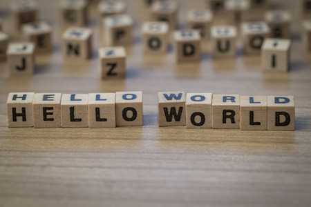 Hello World written in wooden cubes on a tableの写真素材
