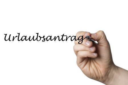 Urlaubsantrag (german application for leave) written by a hand isolated on white backgroundの写真素材