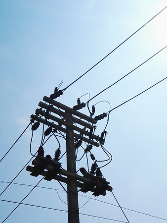 Electrical pole with a bright blue background.
