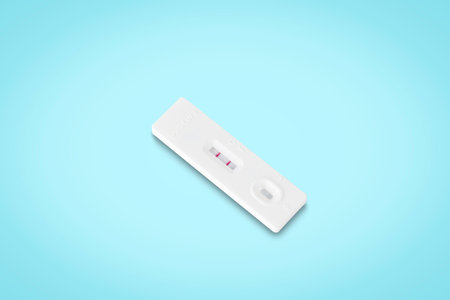 covid-19 positive test result. antigen (ATK) test kitâ isolated onâ light blueâ background with clipping path. top view. flat lay.の写真素材