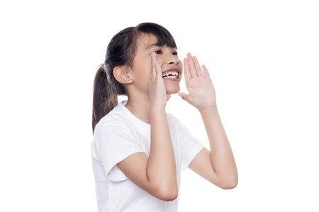 Young Asian girl hands up in a shouting gesture isolated on white background with clipping path. Speaking with hands gesture near mouth.の写真素材