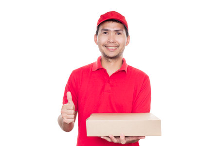 Asian delivery man in red shirt and cap standing with parcel post box isolated on white background with clipping path. Concept Deliveryman.の写真素材