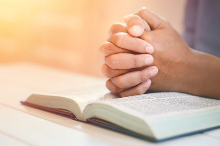 Closeup Man's Praying Hands Over The Bible.の写真素材