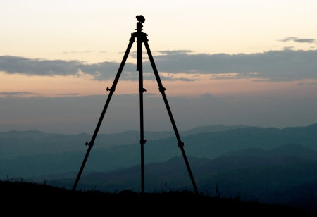 Tripod silhouette on a high hill at sunsetの写真素材