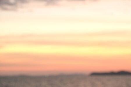 The seaside at sunset has dark shadows in the form of mountainsの写真素材