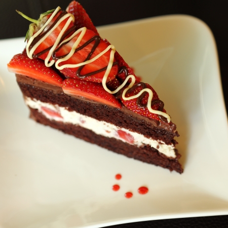 Strawberry Chocolate lover Cake  A chocolate cake with strawberries with slice on the white plate の写真素材