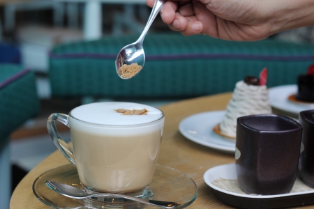 Put the sugar in a cup of coffeeの写真素材