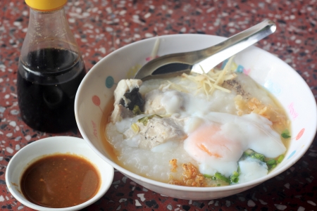 Traditional chinese porridge rice gruel in bowl with fesh fishの写真素材