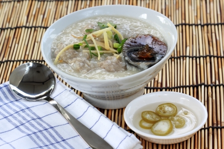 Traditional chinese porridge rice gruel in bowl with pork and Preserved eggの写真素材